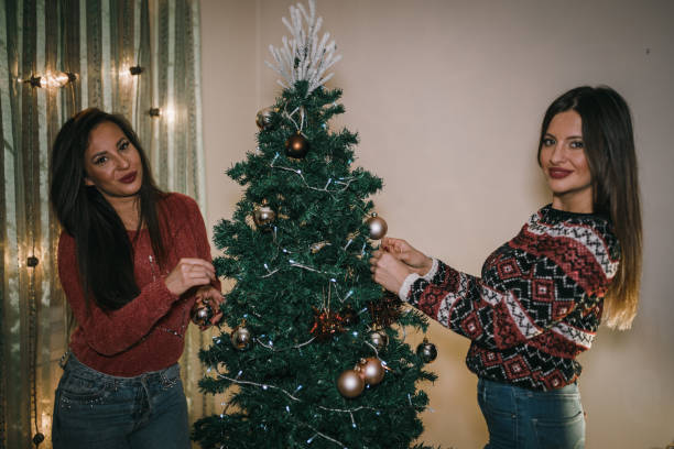 istock Friends having fun and decorating Christmas tree 1057391652