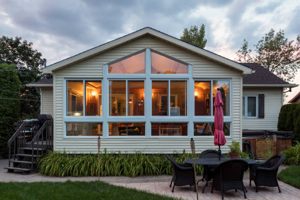 White framed glass conservatory attached to house at sunset, Quebec, canada