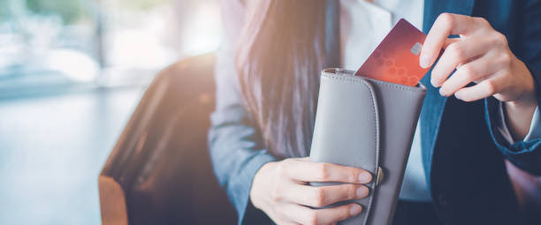 istock Women's hand Using a credit card, she pulled the card out of her wallet.Web banner. 1057416536