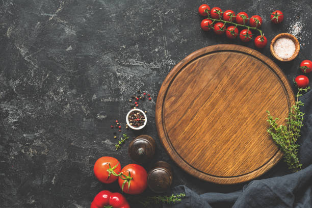 istock Cutting board, spices and vegetables for cooking. Food background 1057423646