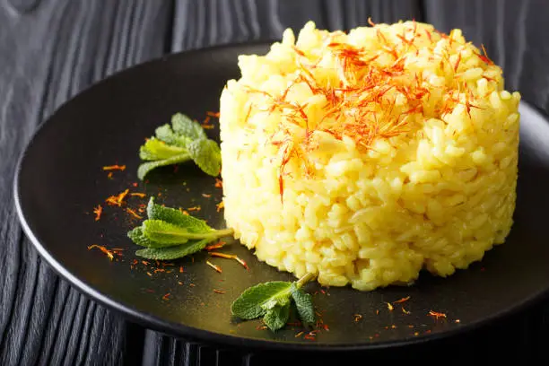 Vegetarian Italian food: risotto with saffron and mint (Risotto alla milanese) closeup on a plate. horizontal