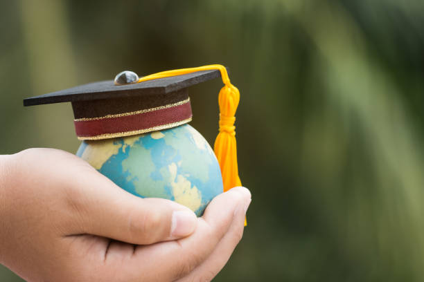istock Education world knowledge ideas. Graduation cap on Businessman holding Earth globe model in hands. Concept of global business study, abroad educational with green blackground, Back to School. 1057433514
