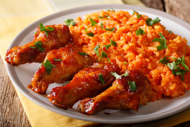 istock Nigerian food party: Jollof rice with fried chicken wings close-up. horizontal 1057433870