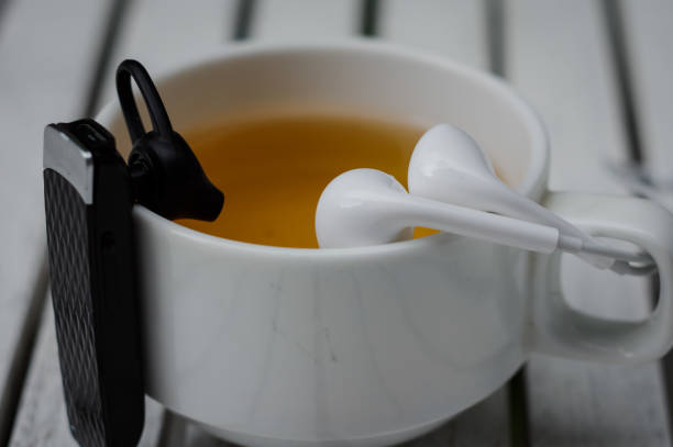 wire & wireless headset na krawędzi filiżanki herbaty - at the edge of audio zdjęcia i obrazy z banku zdjęć