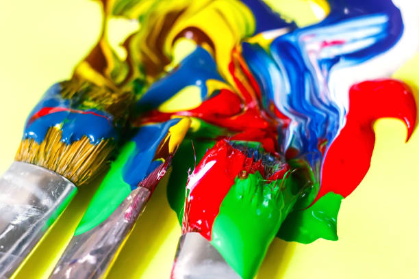 istock acrylic paint and artistic brush squeezed out against a yellow background, close-up, selective focus 1057449080