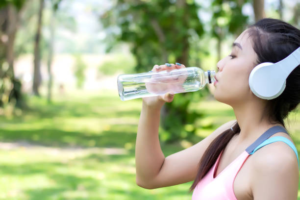 istock Asian young woman drinking water after workout exercising. 1057449250