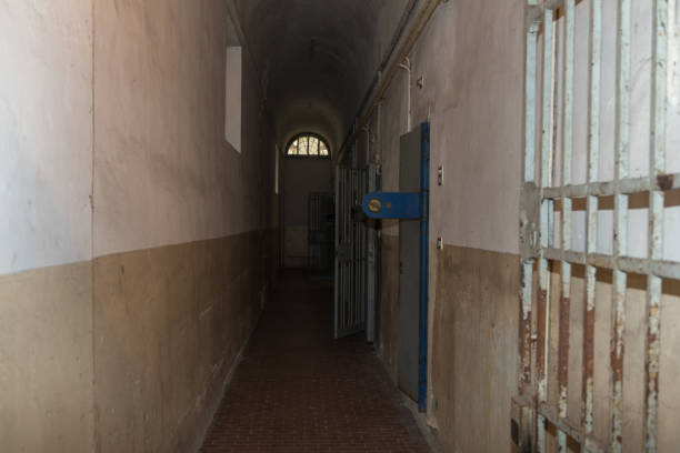istock Long Corridor and White and Worn Walls of a Prison 1057449678