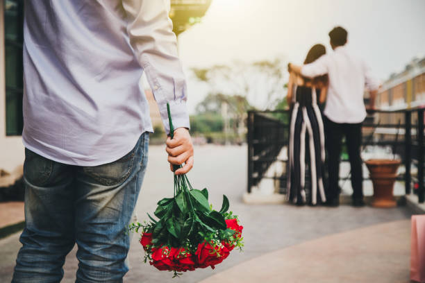 Men prepare flowers for lovers. But his lover is with other people for others. Love concept Men prepare flowers for lovers. But his lover is with other people for others. Love concept infidelity photos stock pictures, royalty-free photos & images