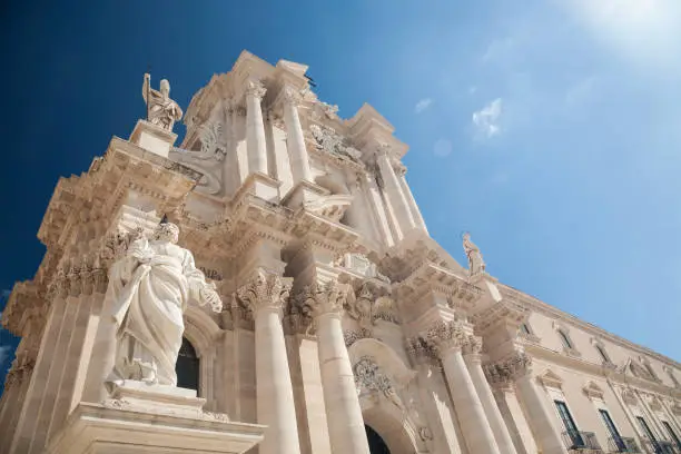 The Sicilian baroque facade of the cathedral of Syracuse with sunflares in the historic center of Ortygia island, Sicily, Italy