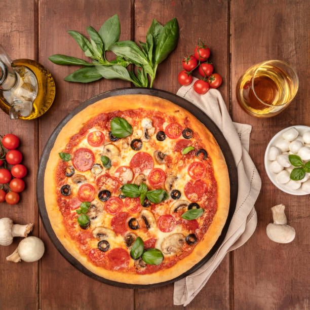 istock Pepperoni pizza with white wine, ingredients, and place for text 1057464768