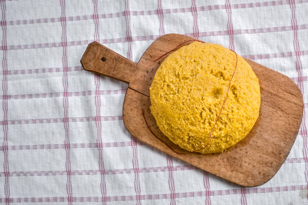 polenta de cuisson à la vapeur chaude sur un ancien en bois - dishware butter cutting board agriculture photos et images de collection