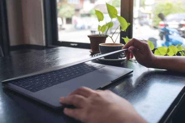 istock Closeup image of hands close and open a laptop computer on table after finished using it 1057475054