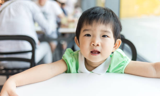 istock Cute baby waiting for lunch in the restaurant 1057477364