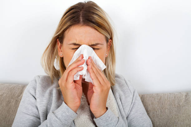 istock Sick woman blowing her nose 1057477372