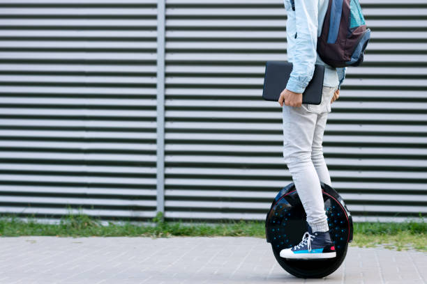 生態学的な電気伝導の上に乗って現代ビジネスマン学生フリーランサー - unicycle unicycling cycling wheel ストックフォトと画像