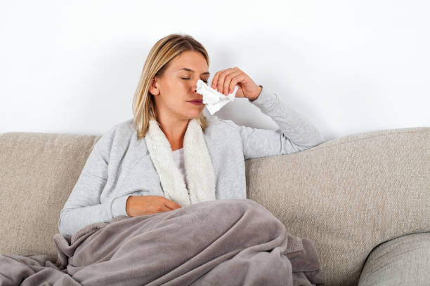 istock Sick woman blowing her nose 1057477450