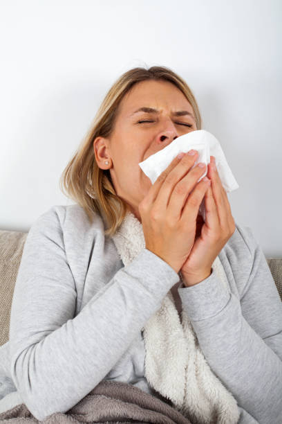 istock Sick woman blowing her nose 1057477612