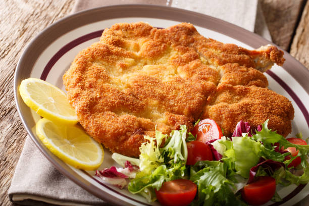 tradicional vitela italiana milanesa com limão e close-up de salada de legumes frescos. horizontal - cutlet schnitzel pork scaloppini - fotografias e filmes do acervo