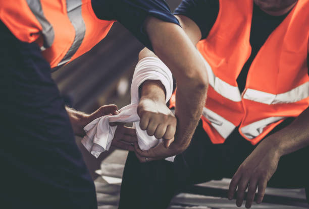 Close up of physical injury at work. Close up of unrecognizable manual worker assisting his colleague with physical injury in steel mill. injured stock pictures, royalty-free photos & images
