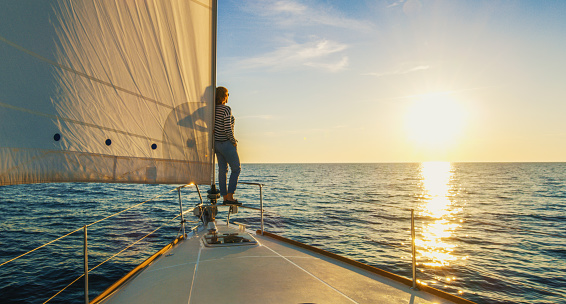 Woman staying on edge of prow and looking at sunset, Croatia