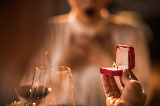 Close up of unrecognizable man giving his wife a ring for their anniversary.