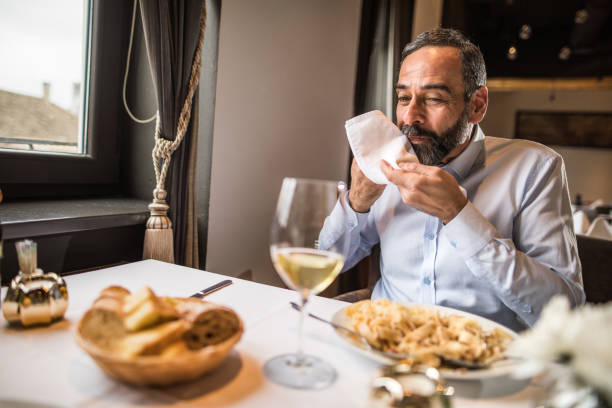 istock Senior man wiping his mouth after dinner in a restaurant. 1057490320