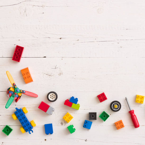 istock Top view on colorful plastic toy and bricks on white wooden table background. 1057491564