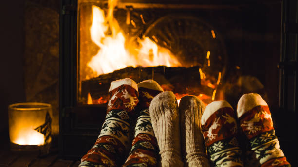 Closeup of three people feet by fireplace Closeup of three people feet dressed in warm socks by fireplace heat home interior comfortable human foot stock pictures, royalty-free photos & images