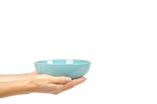 Blue empty ceramic bowl with hand isolated on white background, copy space template.