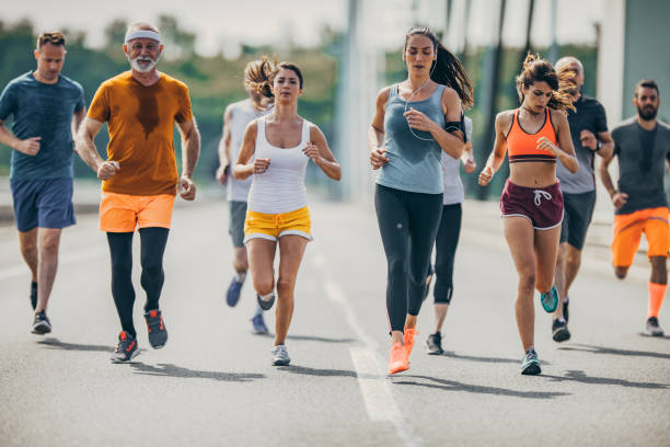 istock Large group of mix-aged marathon runners on a road. 1057494220