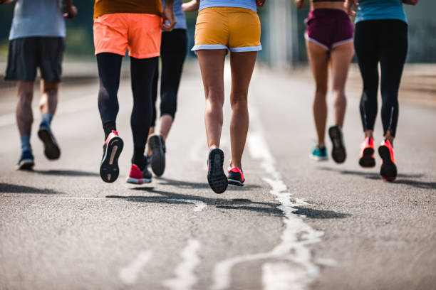 istock Unrecognizable athletic people running a marathon on the road. 1057494310