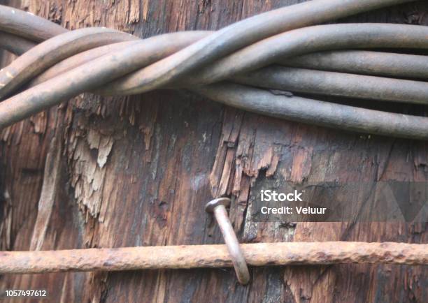 Industrial Image Of A Thick Wire Wrapped Around A Wooden Pole A Hammered  Nail Stock Photo - Download Image Now - iStock