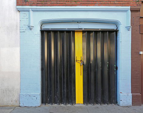 Closed Black Accordion Doors Locked With Padlock and Chain