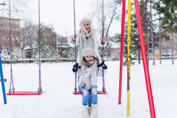 istock Swinging in winter park. 1057502956