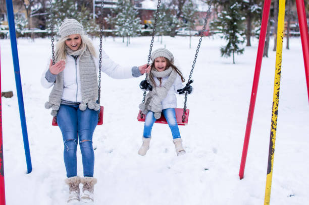 istock Swinging in winter park. 1057503196