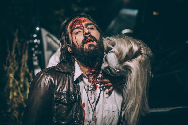 Undead woman biting young man Woman dressed as witch biting man at night. Zombie concept male vampire biting his victim stock pictures, royalty-free photos & images