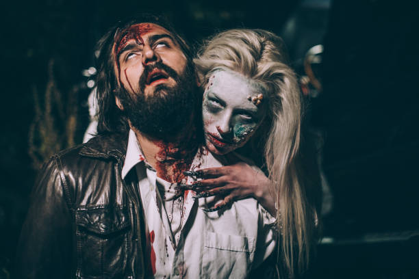 Undead woman biting man Woman dressed as witch biting man at night. Zombie concept male vampire biting his victim stock pictures, royalty-free photos & images