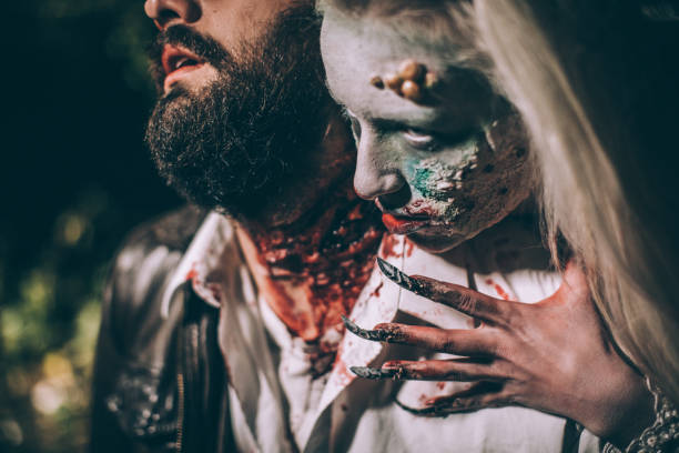 Undead woman biting young man at night Woman dressed as witch biting man at night. Zombie concept male vampire biting his victim stock pictures, royalty-free photos & images