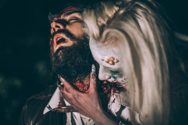 Undead zombie woman biting man Woman dressed as witch biting man at night. Zombie concept male vampire biting his victim stock pictures, royalty-free photos & images