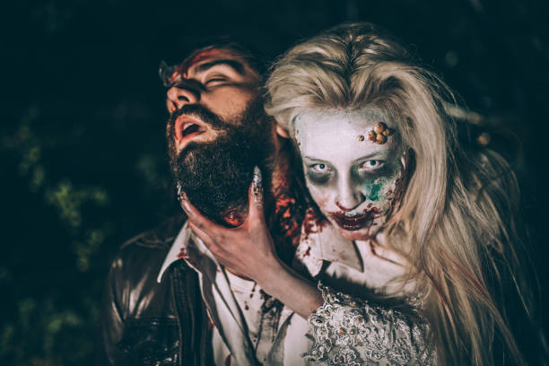 Zombie woman biting man Woman dressed as witch biting man at night. Zombie concept male vampire biting his victim stock pictures, royalty-free photos & images