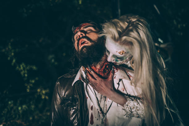Zombie woman biting young man Woman dressed as witch biting man at night. Zombie concept male vampire biting his victim stock pictures, royalty-free photos & images
