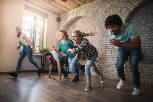 Group of happy friends having fun while starting a race at casual office.