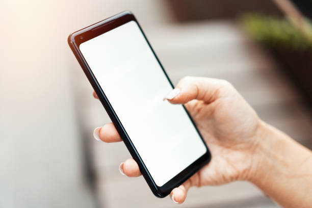 istock Woman hand holding mobile phone with blank empty screen. 1057514674
