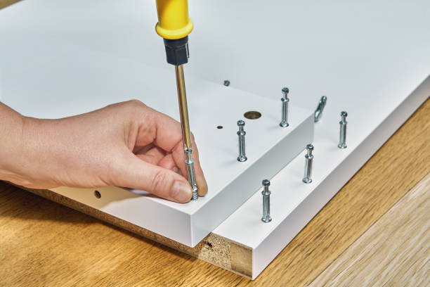 using furniture fasteners for mounting the flatpack. - screwdriver screw tighten fastener imagens e fotografias de stock