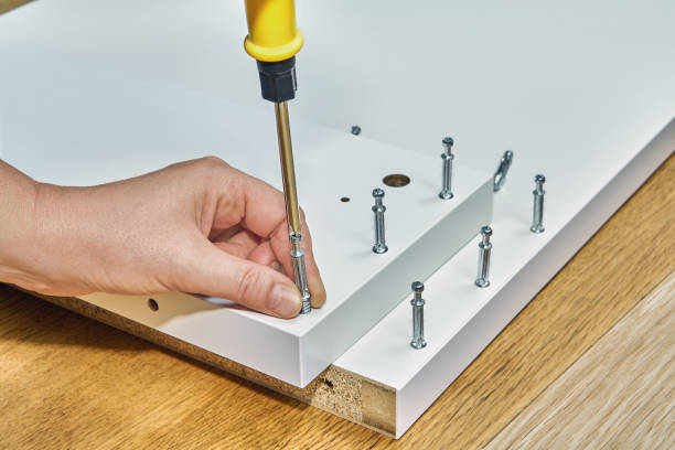 использование мебельных креплений для монтажа плоскогопака. - screwdriver screw tighten fastener стоковые фото и изображения