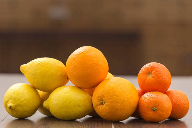 still life with piles separating citrus fruits placed together in groups, on a background and surface of brown tones