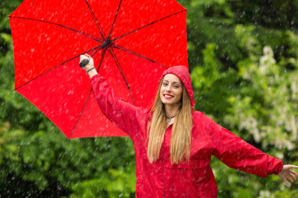 istock Woman with umbrella having fun in rainy day 1057519362