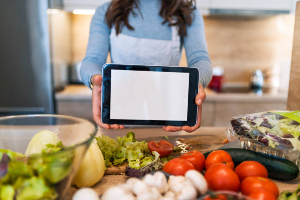 istock Kitchen woman making healthy food with tablet computer 1057536308
