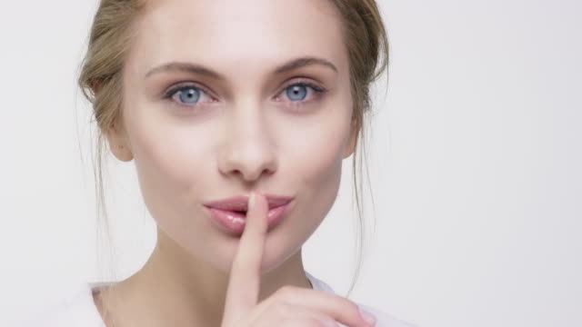 Portrait of beautiful woman with finger on lips