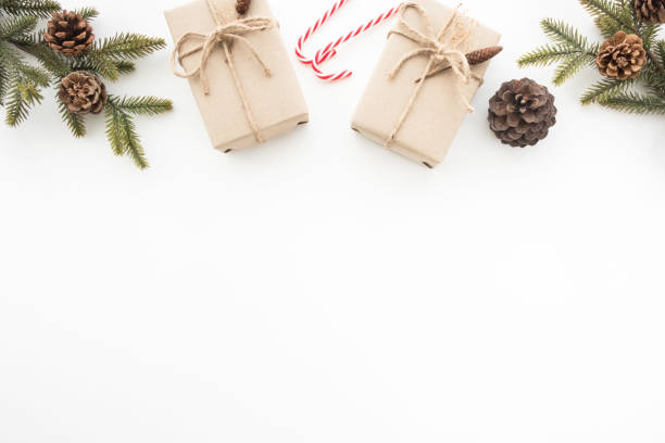 istock Gift boxes with pine branches and pine cones are on top of white desk table during Christmas or new year. Top view with copy space, flat lay. 1057538992